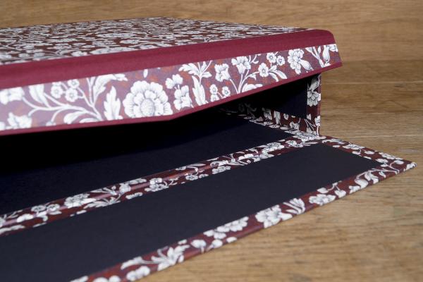 Close-up of blue box, cover material Italian colored paper blue with floral ornaments, black inside